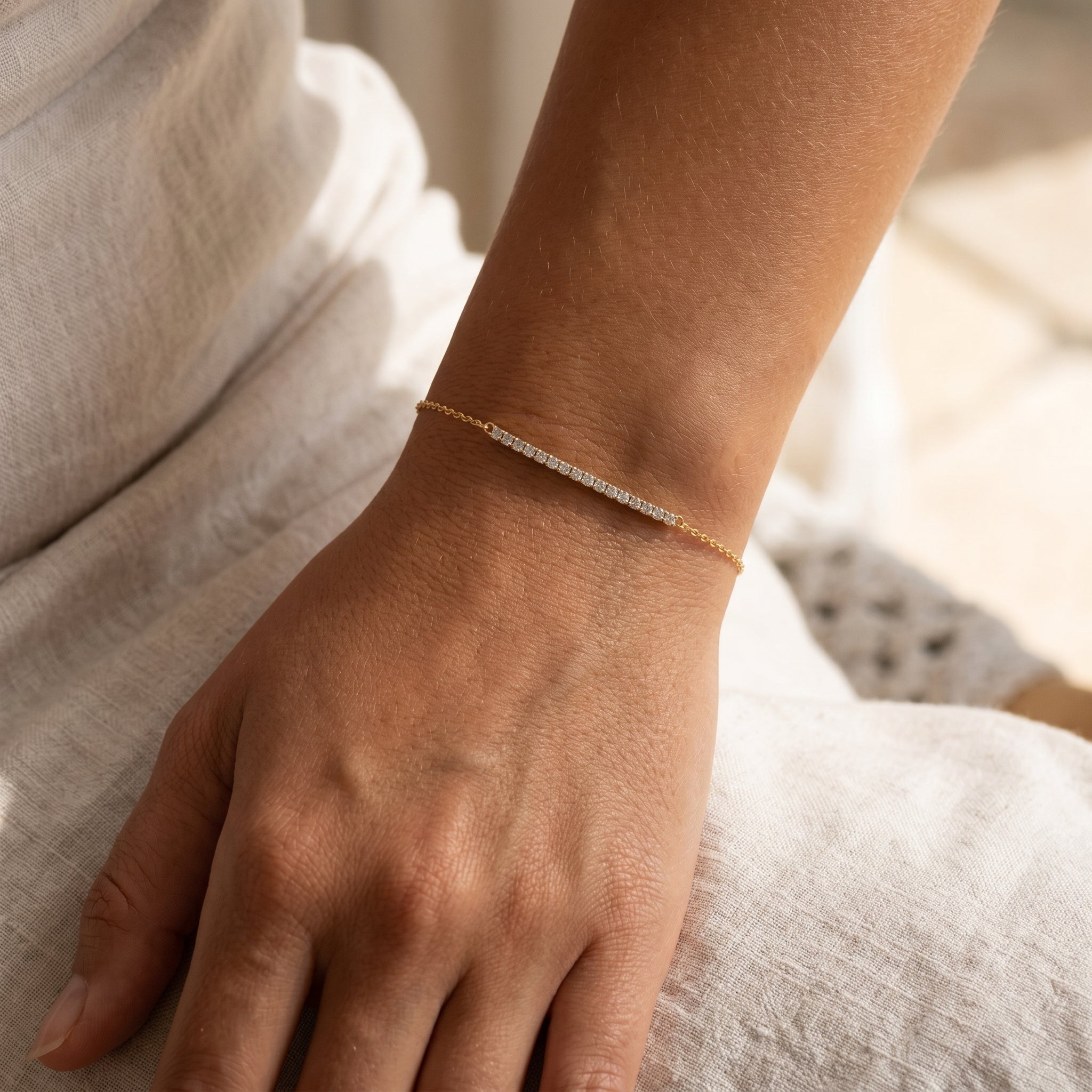 model wearing diamond bar bracelet with a gold chain