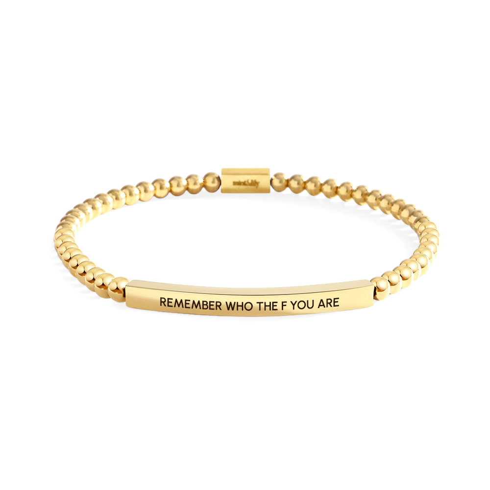 Gold bracelet with engraved text on a white background