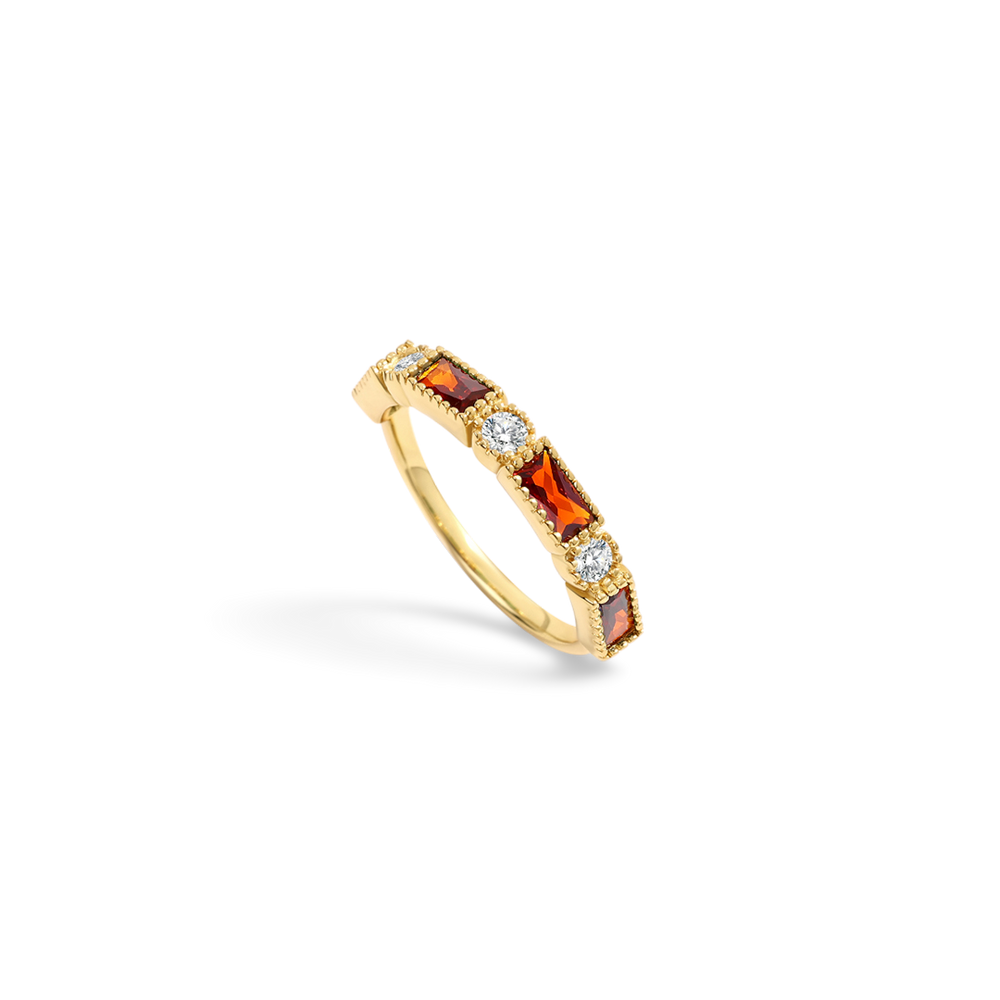Gold ring with red gemstones and clear stones on a light gray background