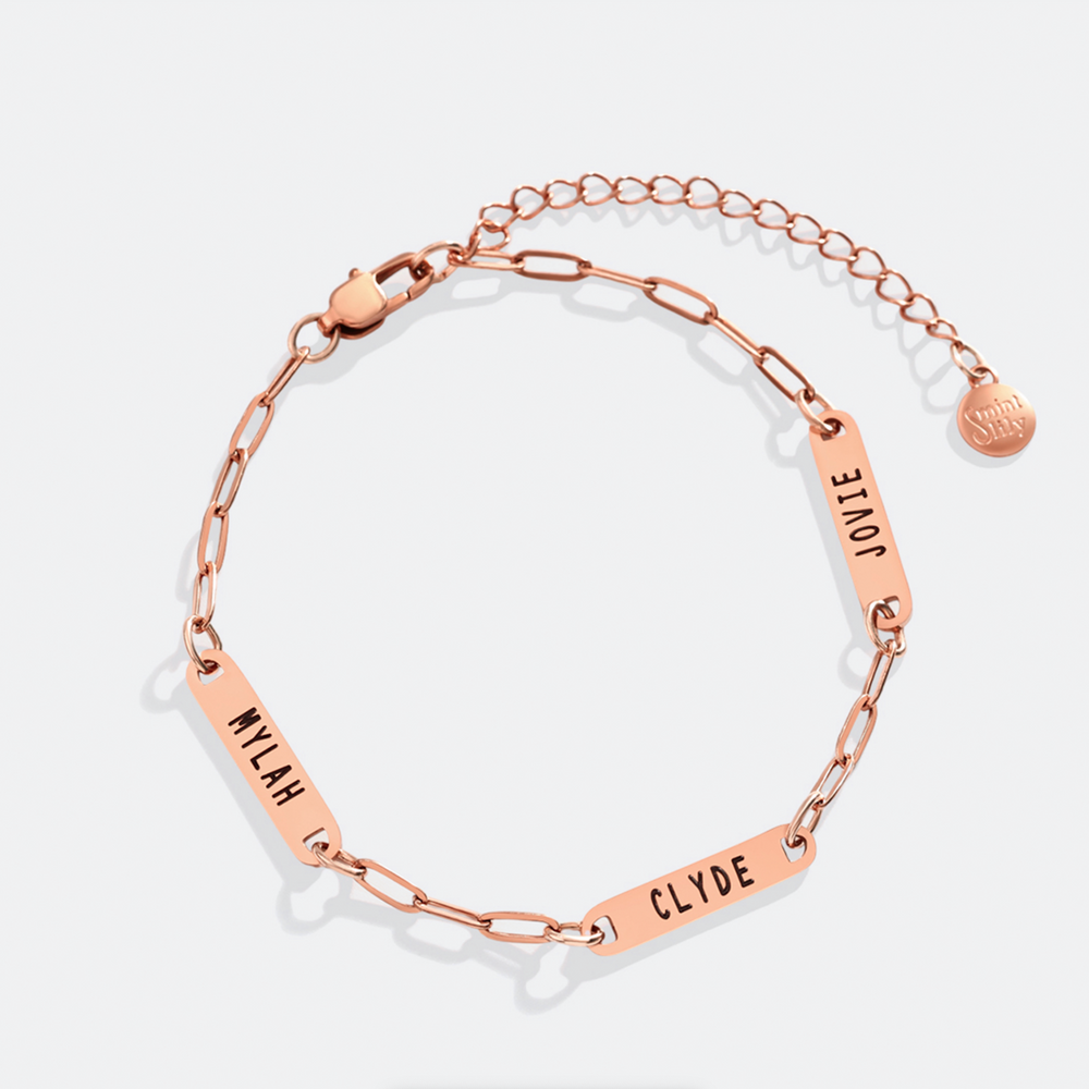Rose gold bracelet with name tags on a light gray background