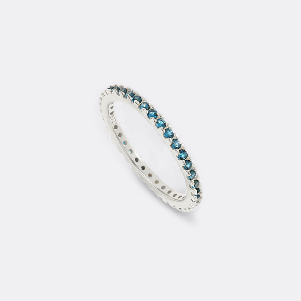 Silver ring with blue gemstones on a light gray background