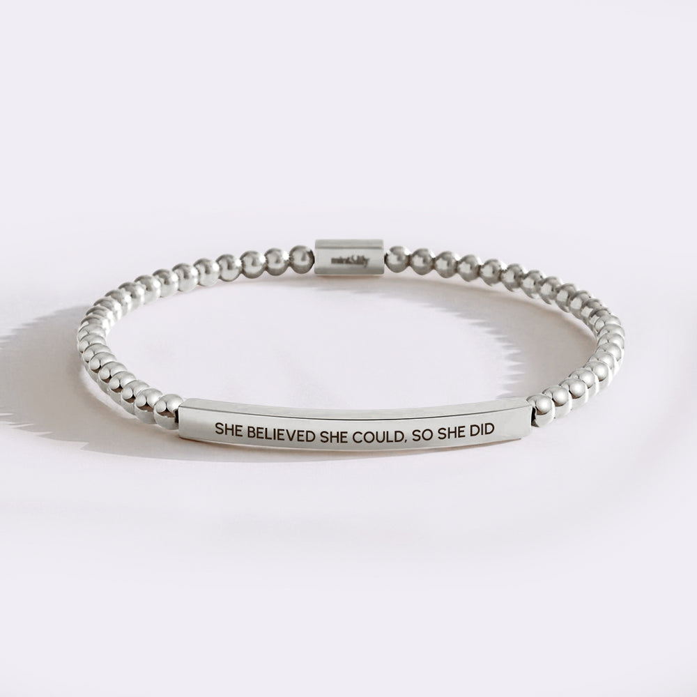 Silver beaded bracelet with engraved message on a white background
