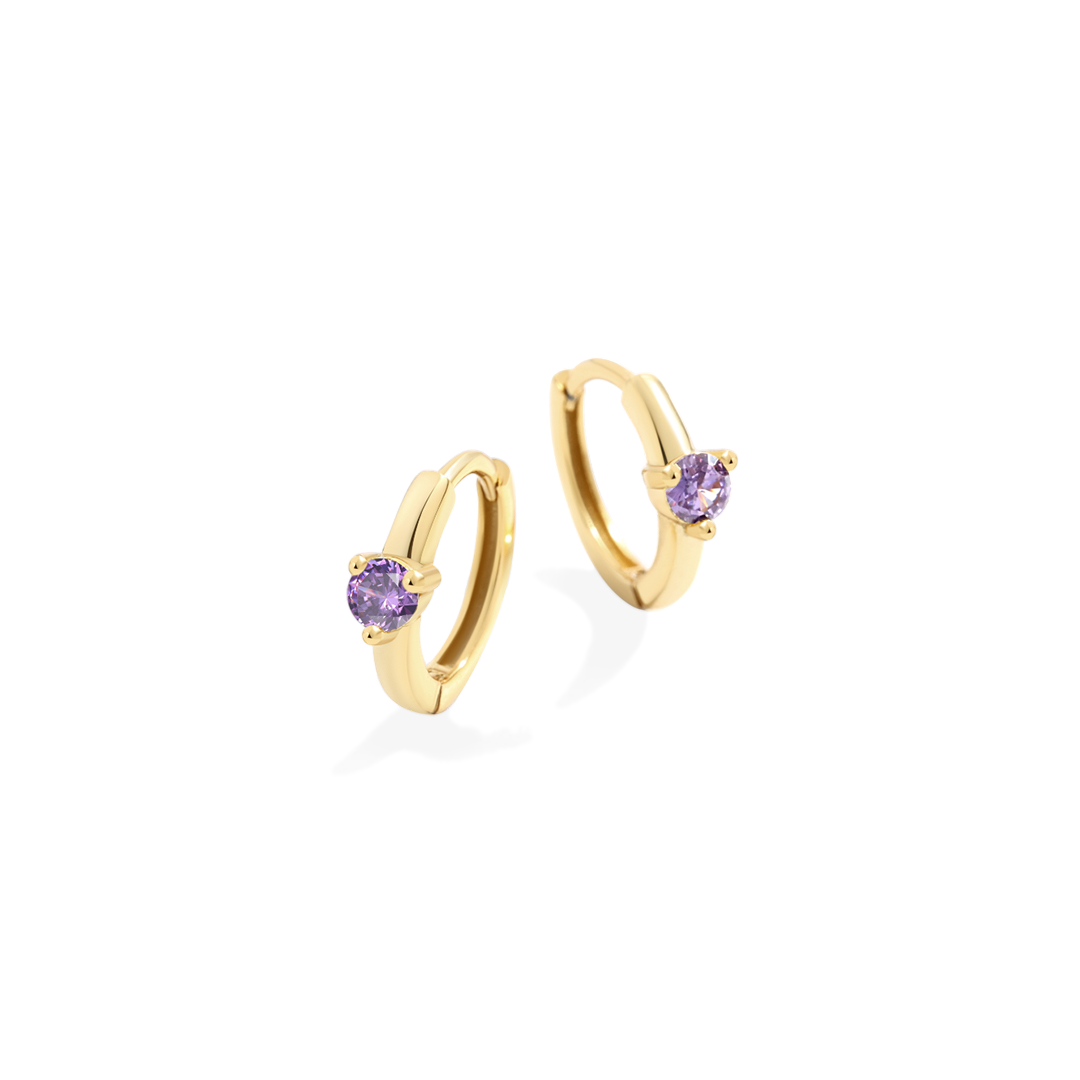 Gold hoop earrings with purple gemstones on a light gray background