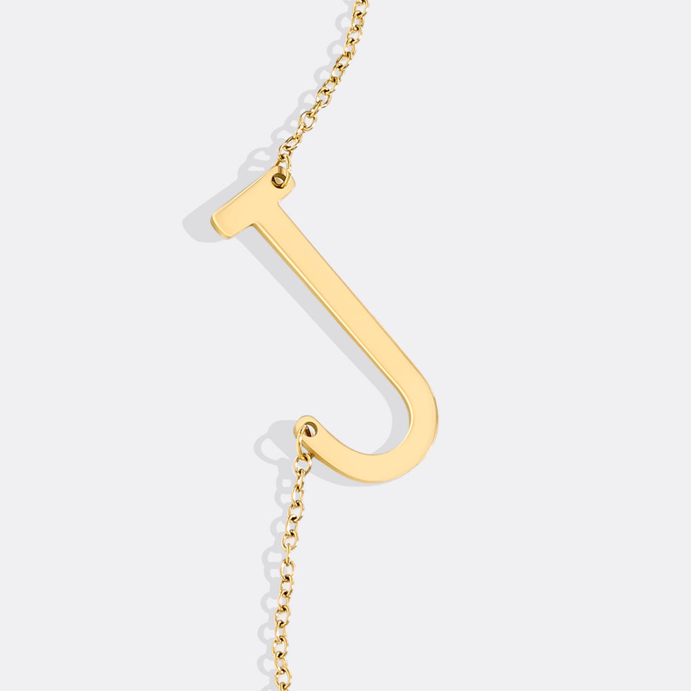 Gold necklace with a unique pendant on a light gray background