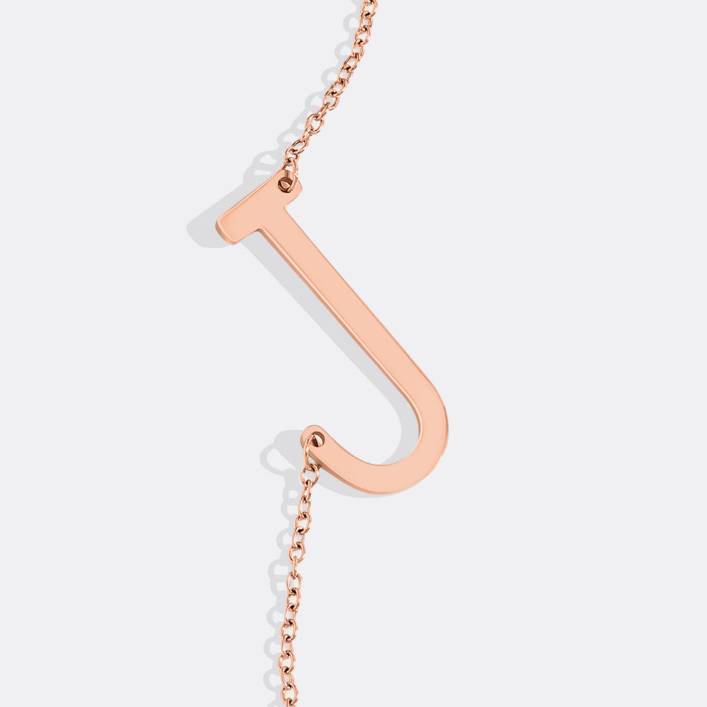 Rose gold necklace with a unique pendant on a light gray background