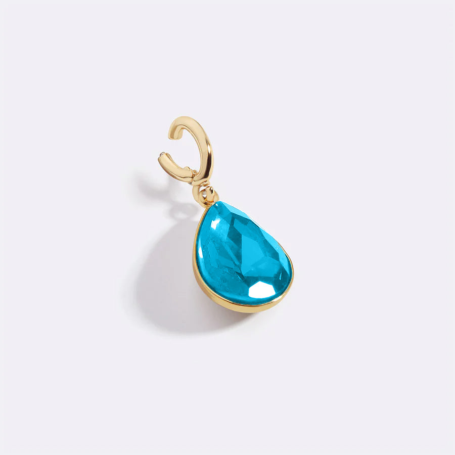 Gold pendant with a blue teardrop-shaped gemstone on a white background