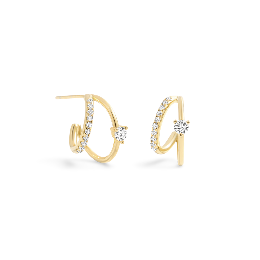Gold hoop earrings with clear gemstones on a light gray background