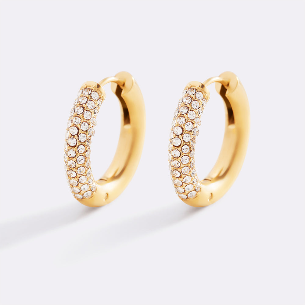 Gold hoop earrings with embedded stones on a light gray background