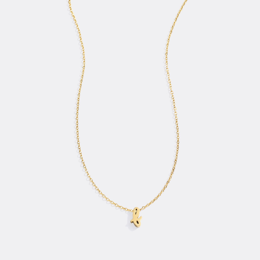 Gold necklace with a small pendant on a light gray background