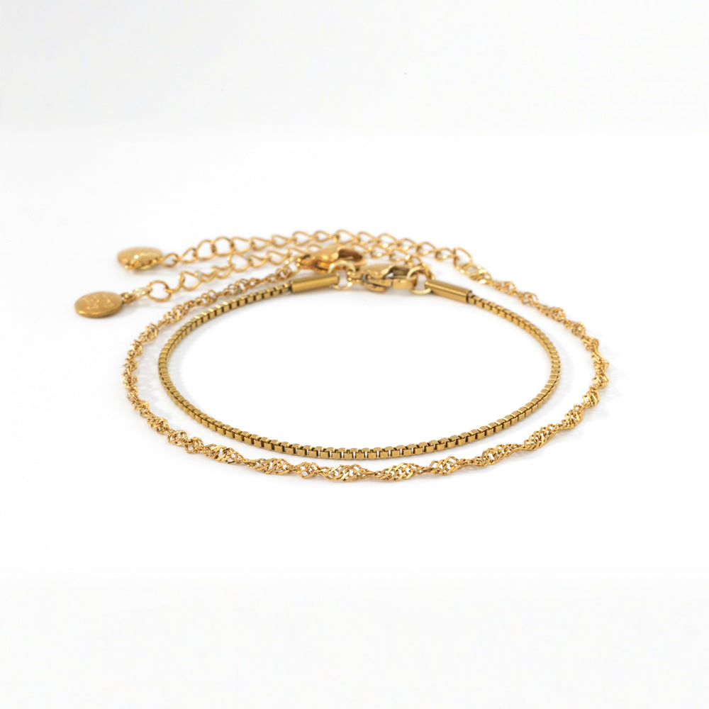 Gold Singapore twist chain bracelet and gold box chain bracelet laid side by side on a white background.
