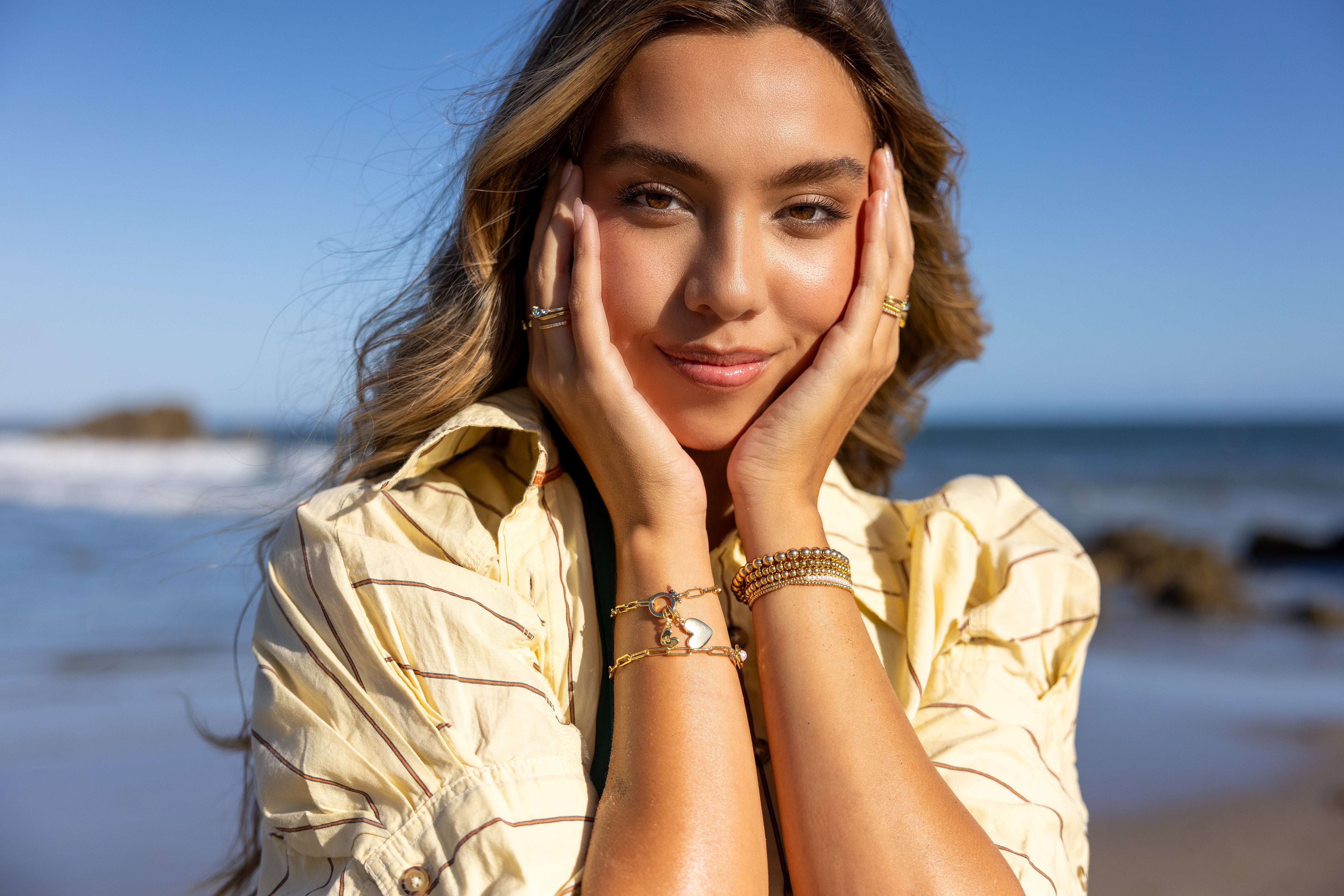 Woman in a yellow shirt with jewelry on a beach