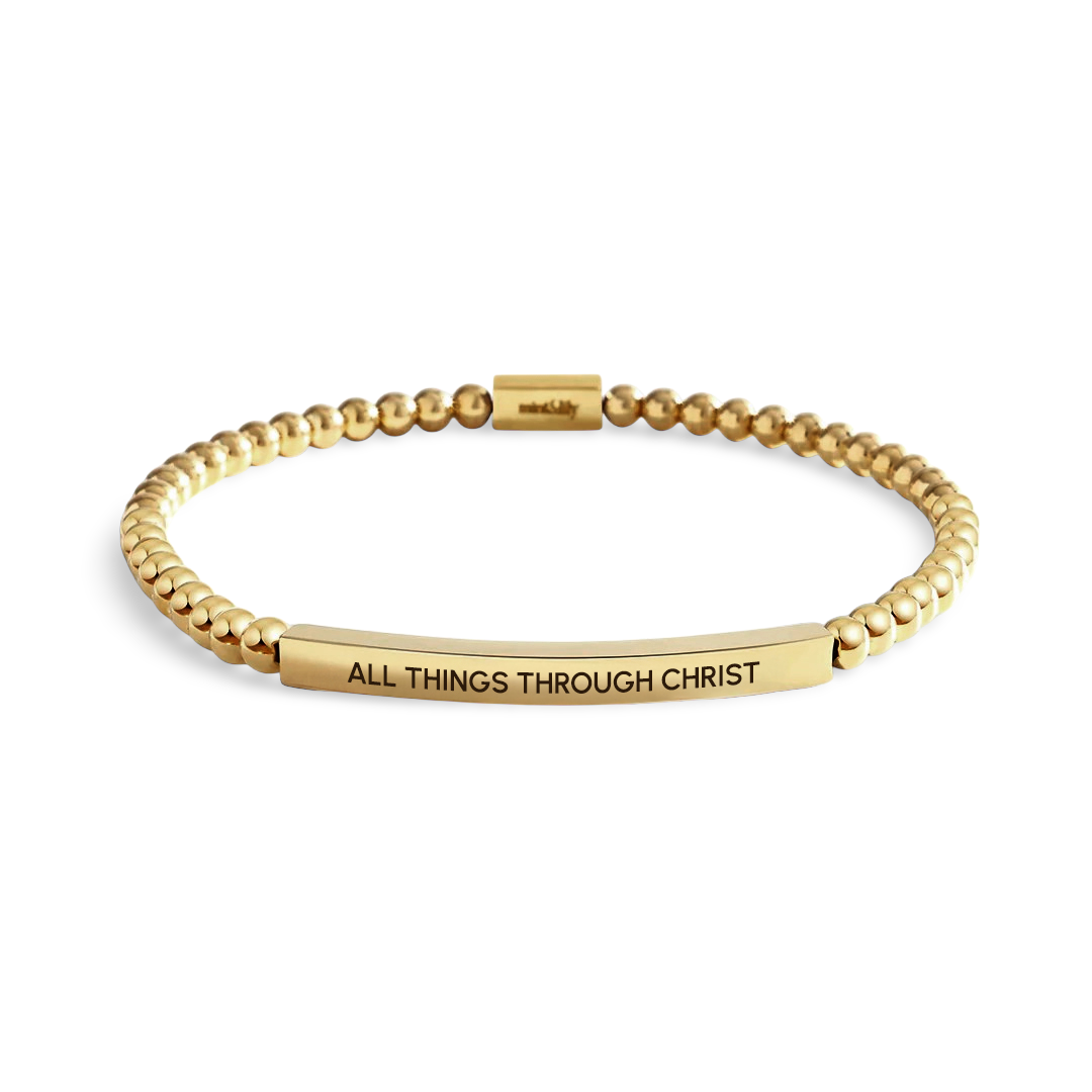 Gold bracelet with 'All Things Through Christ' engraving on a white background
