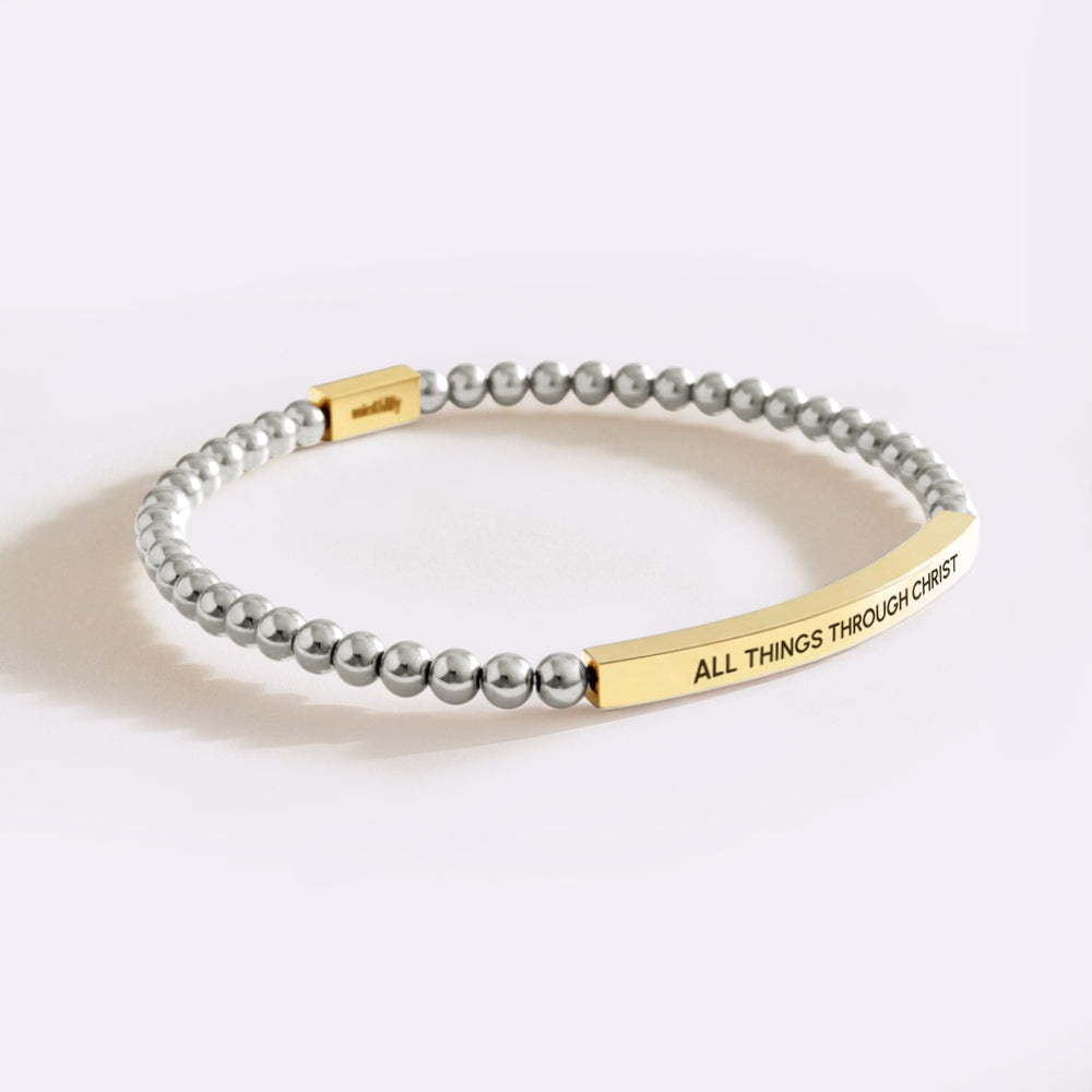 Bracelet with gray beads and gold tag on a white background