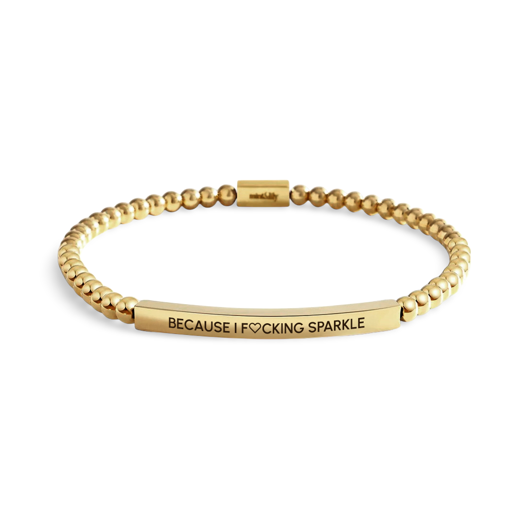 Gold bracelet with engraved text on a light background