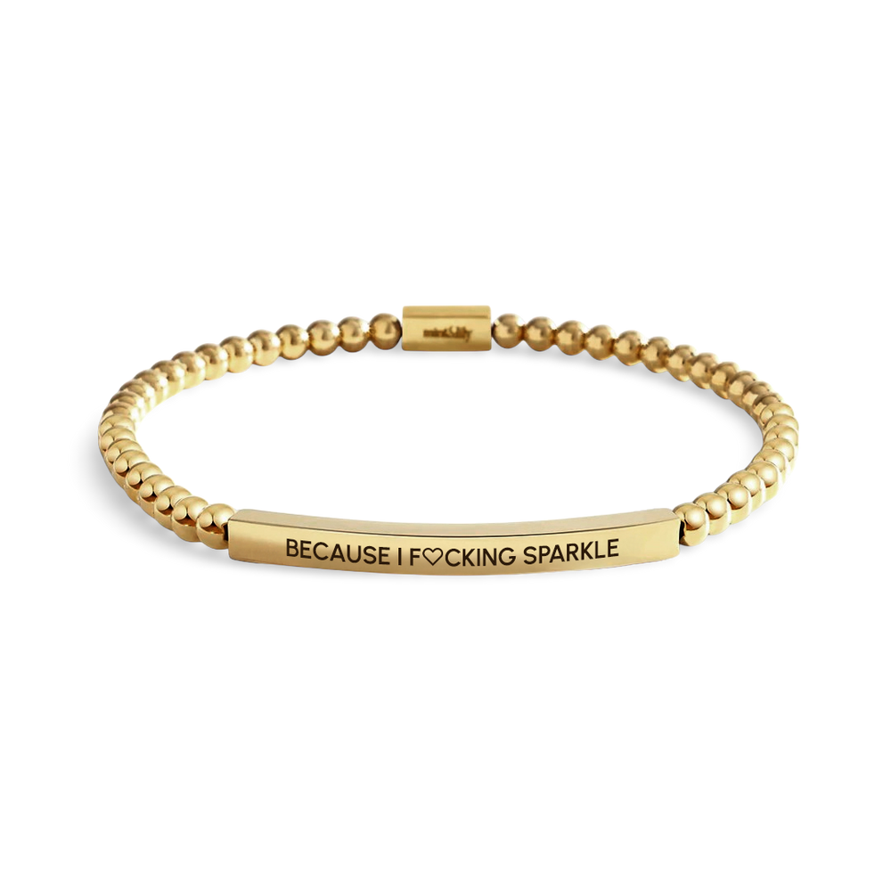 Gold bracelet with engraved text on a light background