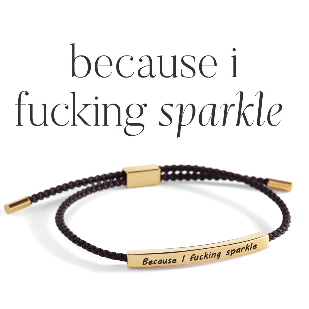A braided bracelet with gold plating and a text charm that reads 'because i fucking sparkle'