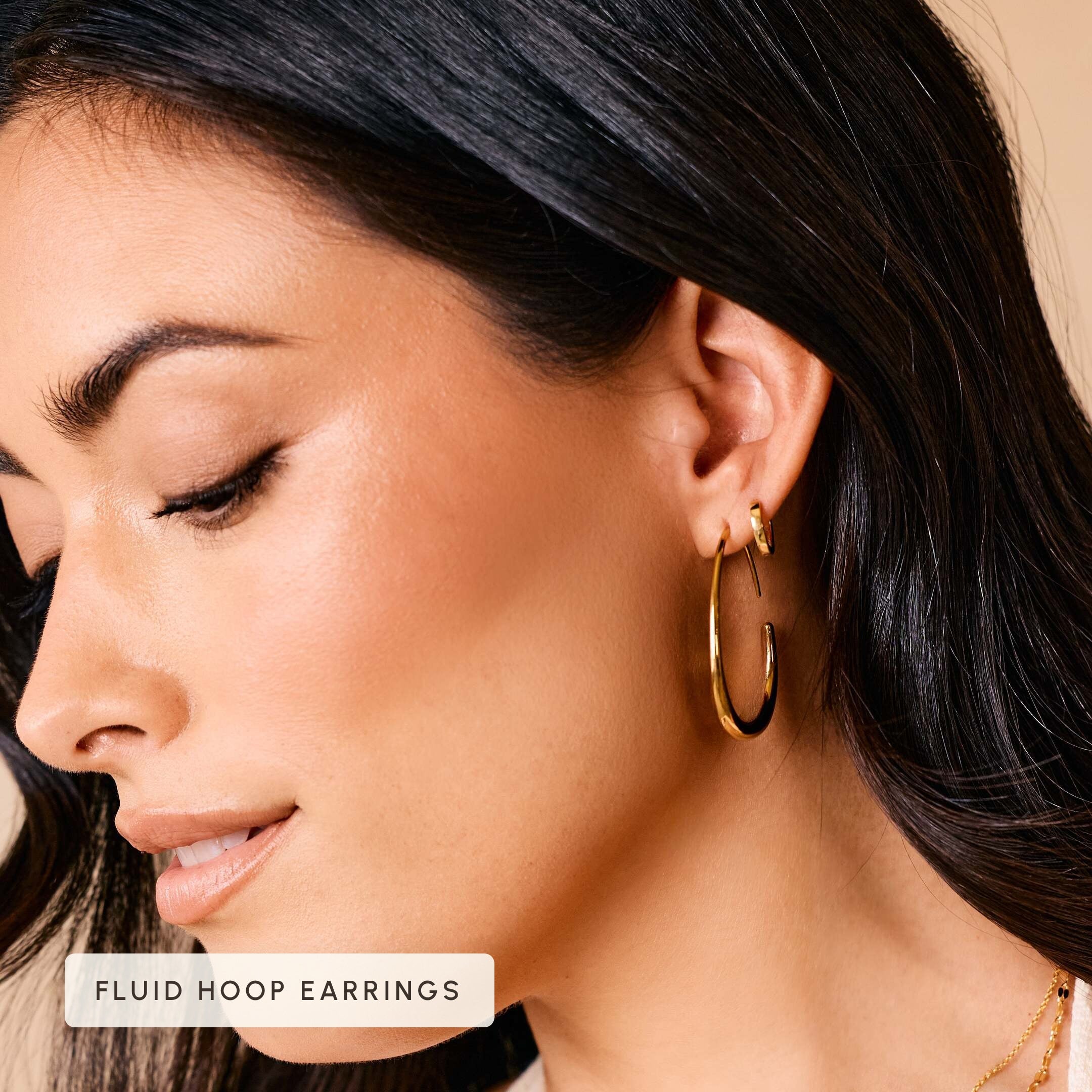 Fluid hoop earrings worn on model