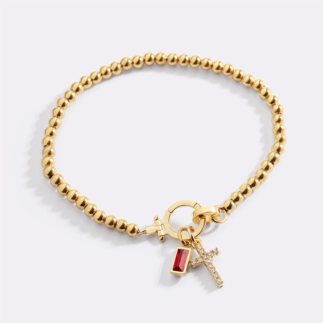 Birthstone cross charm bracelet with January garnet in gold — Mint & Lily