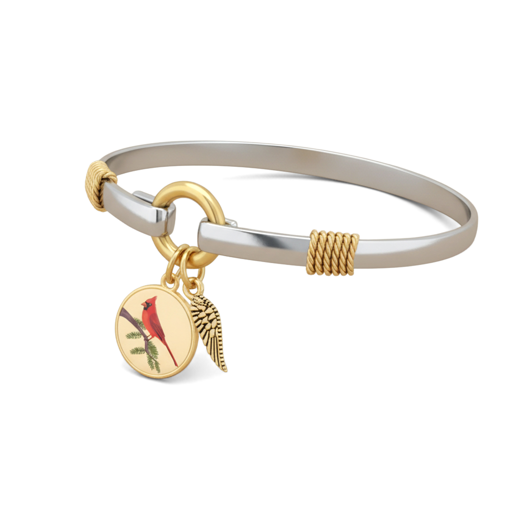 Silver bangle with gold accents and a bird charm on a white background