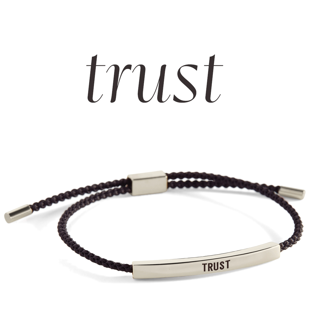 Bracelet with 'TRUST' engraving on a light gray background