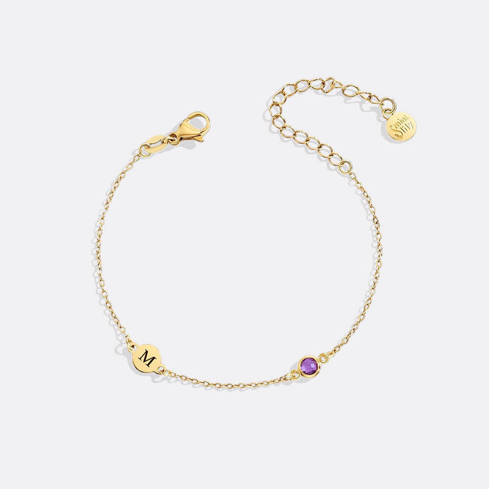 Gold bracelet with a purple gemstone on a white background