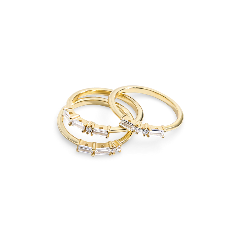 Set of gold rings with diamond accents on a light gray background
