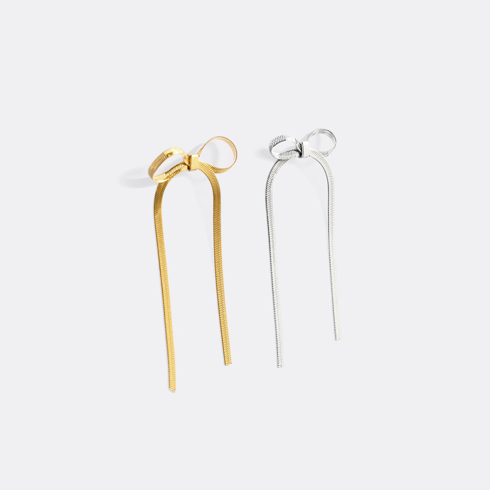 Gold and silver hairpin with bow design on a white background