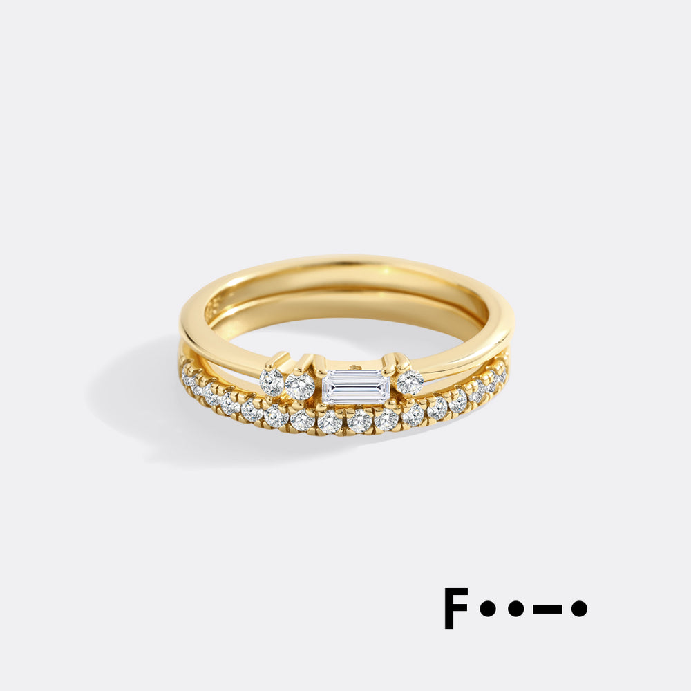 Gold ring with diamonds on a light gray background