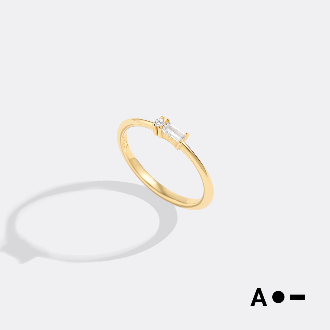 Gold ring with a diamond on a light gray background