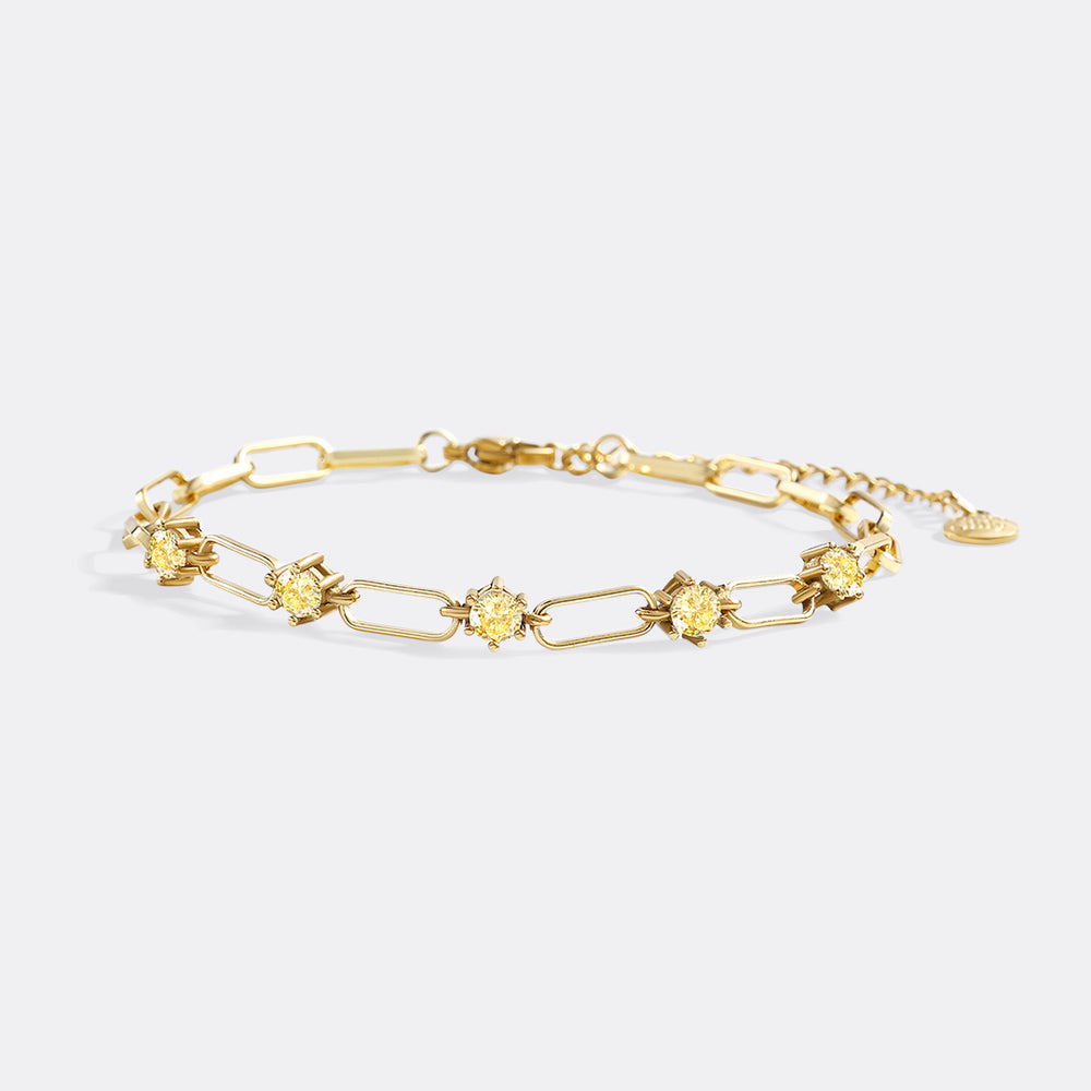 Gold bracelet with floral links on a light gray background