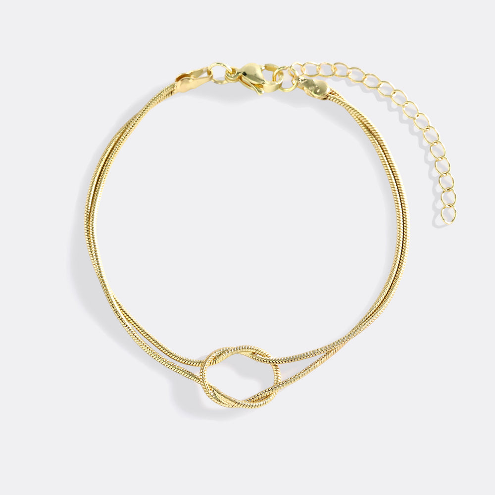 Gold bracelet on a light gray background
