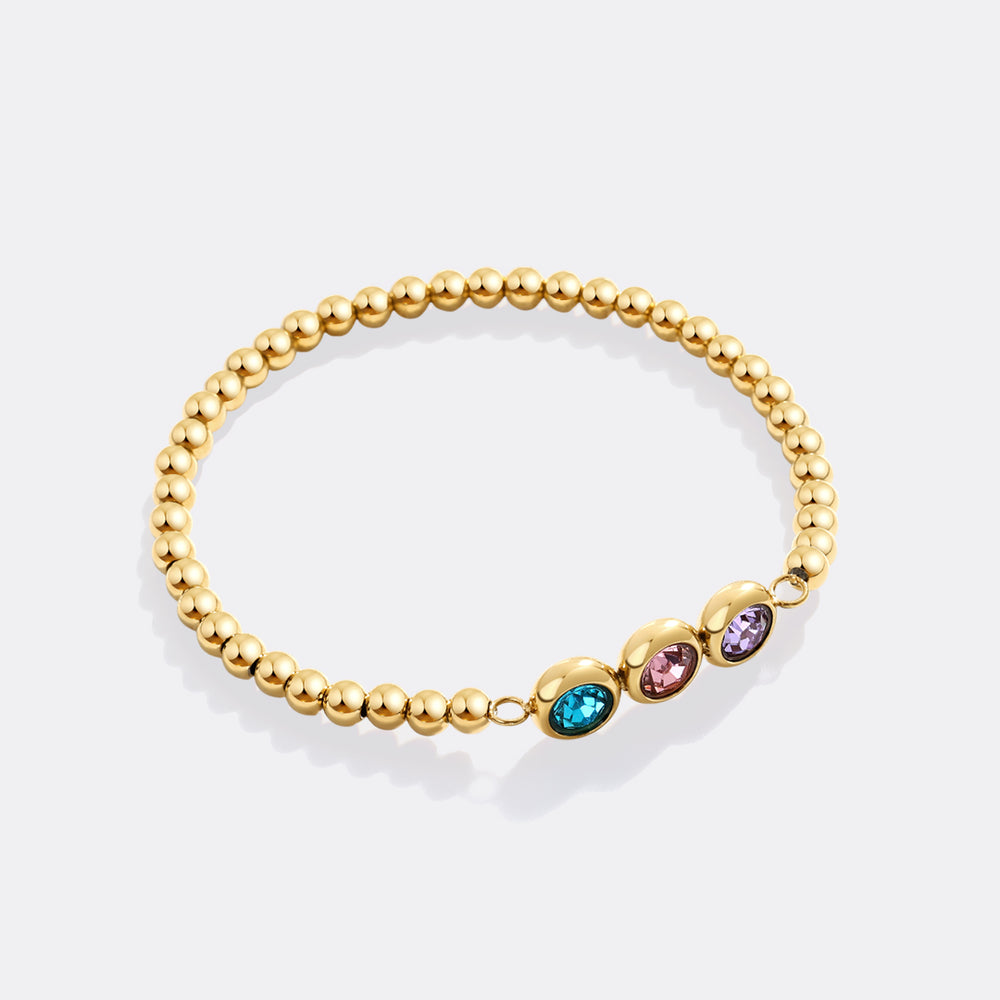 Gold beaded bracelet with colorful gemstones on a white background