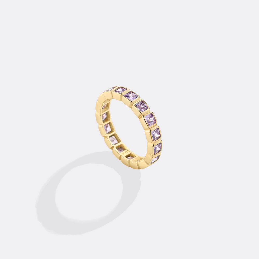 Gold ring with purple gemstones on a white background