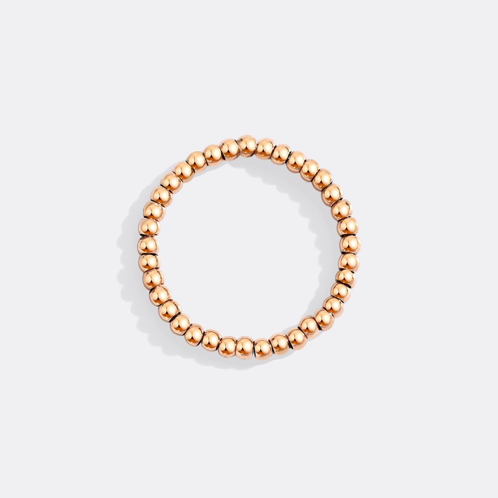 Rose gold beaded ring on a light gray background