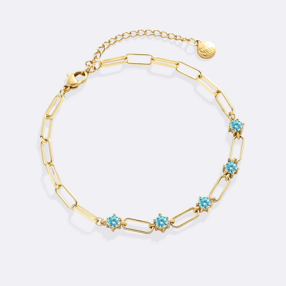 Gold bracelet with turquoise stones on a white background