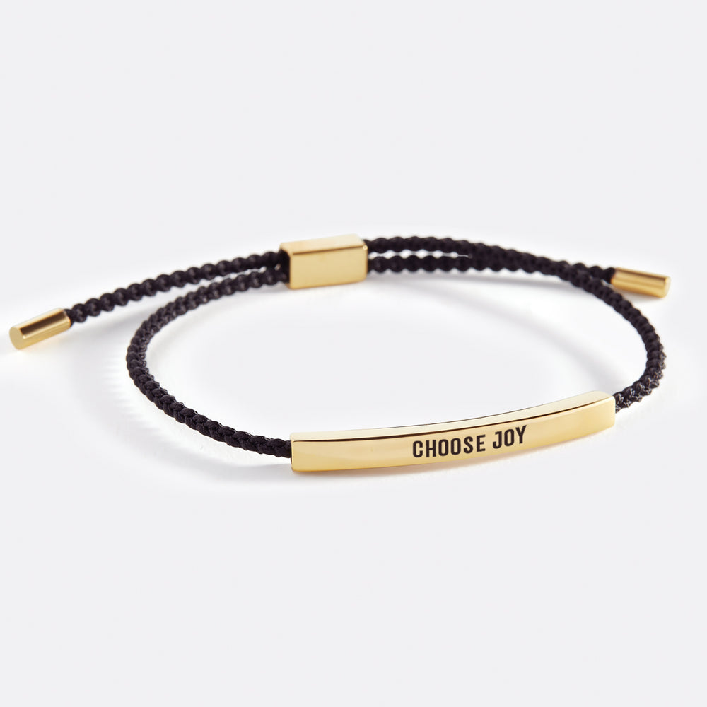 A bracelet with the text 'choose joy' printed on it, displayed on a white background.