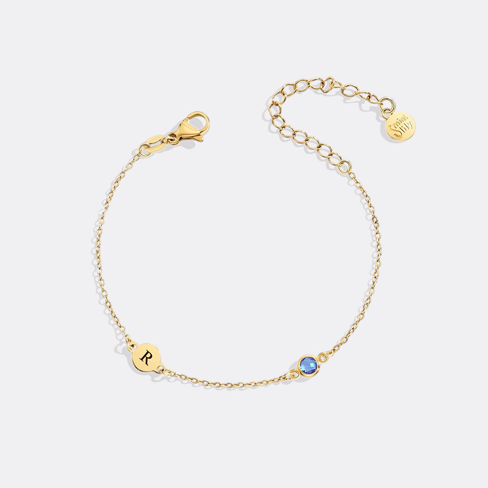 Gold bracelet with a blue gemstone on a white background
