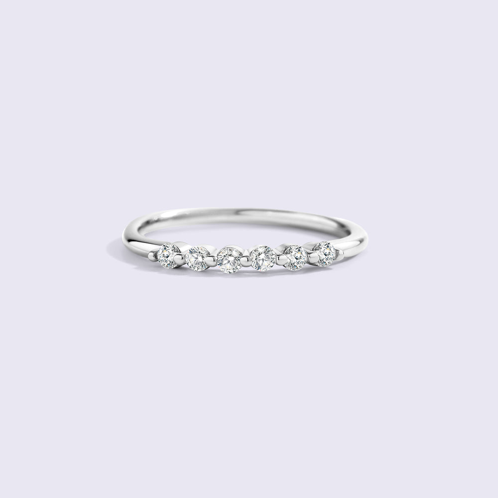 Silver ring with small diamonds on a light gray background