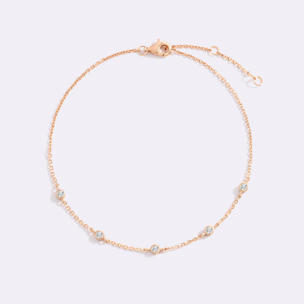 Rose gold bracelet with small diamonds on a light gray background