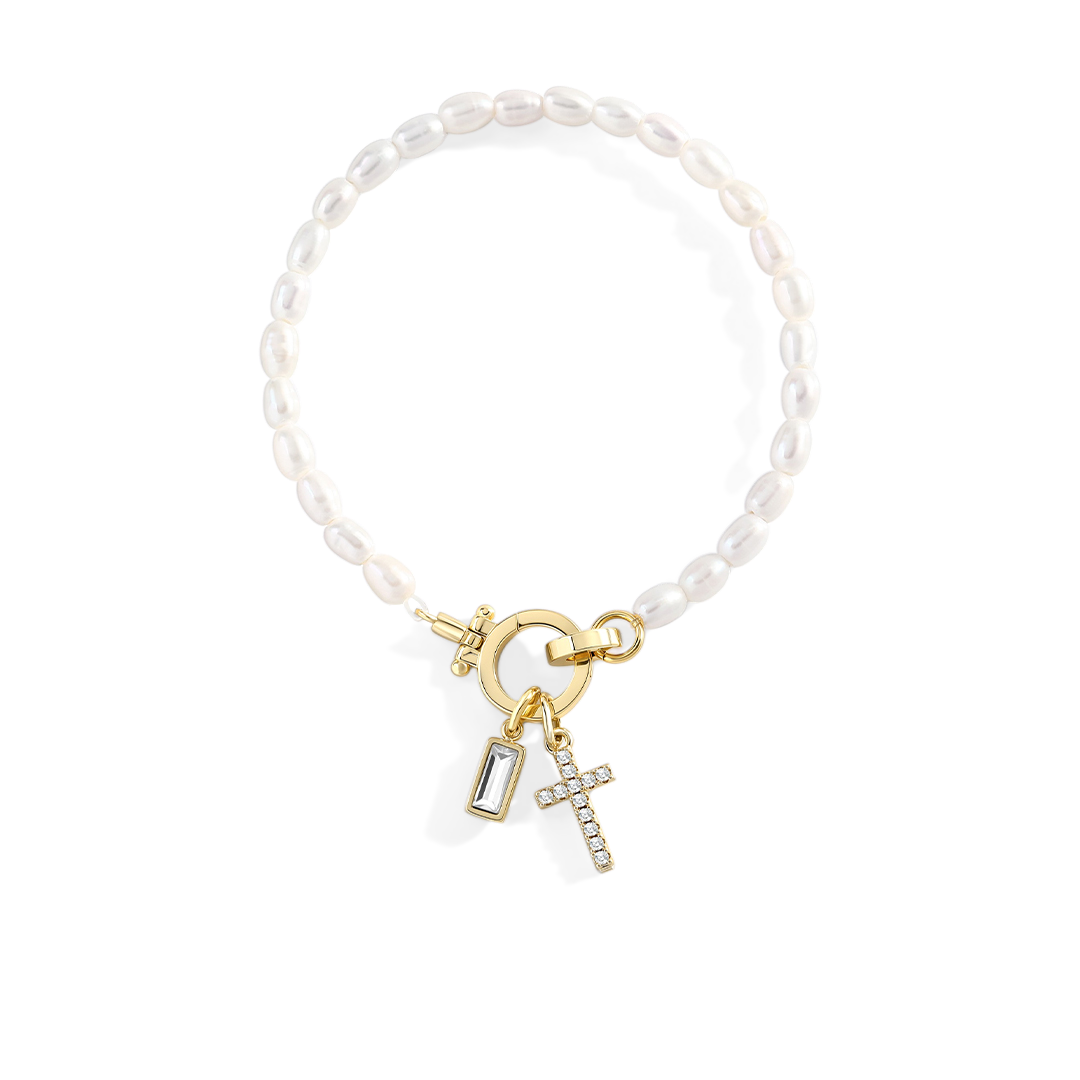 Pearl bracelet with gold charms on a light gray background
