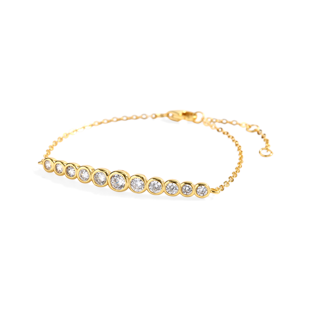 Gold bracelet with clear stones on a light gray background