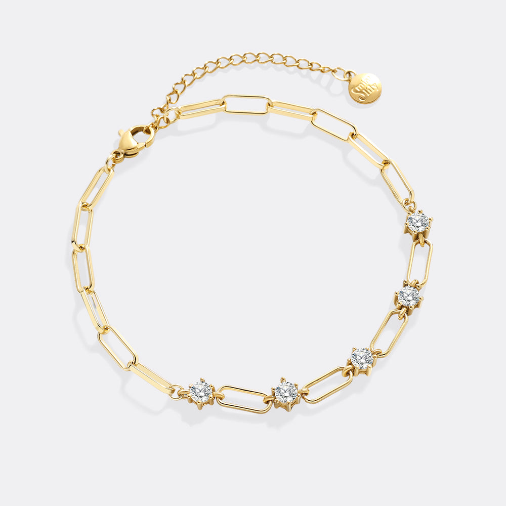 Gold bracelet with diamond-like stones on a white background