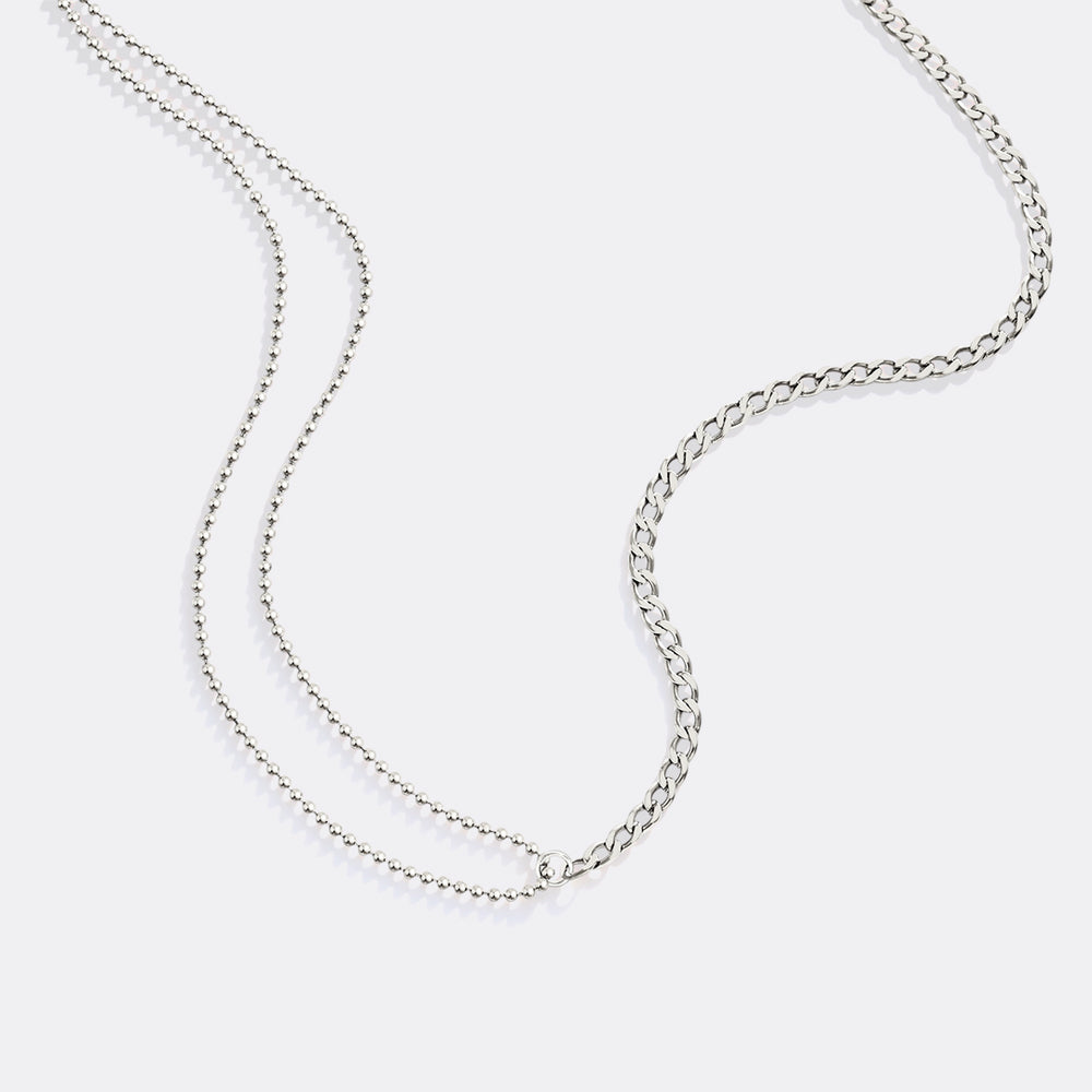 Silver chain necklace on a light gray background