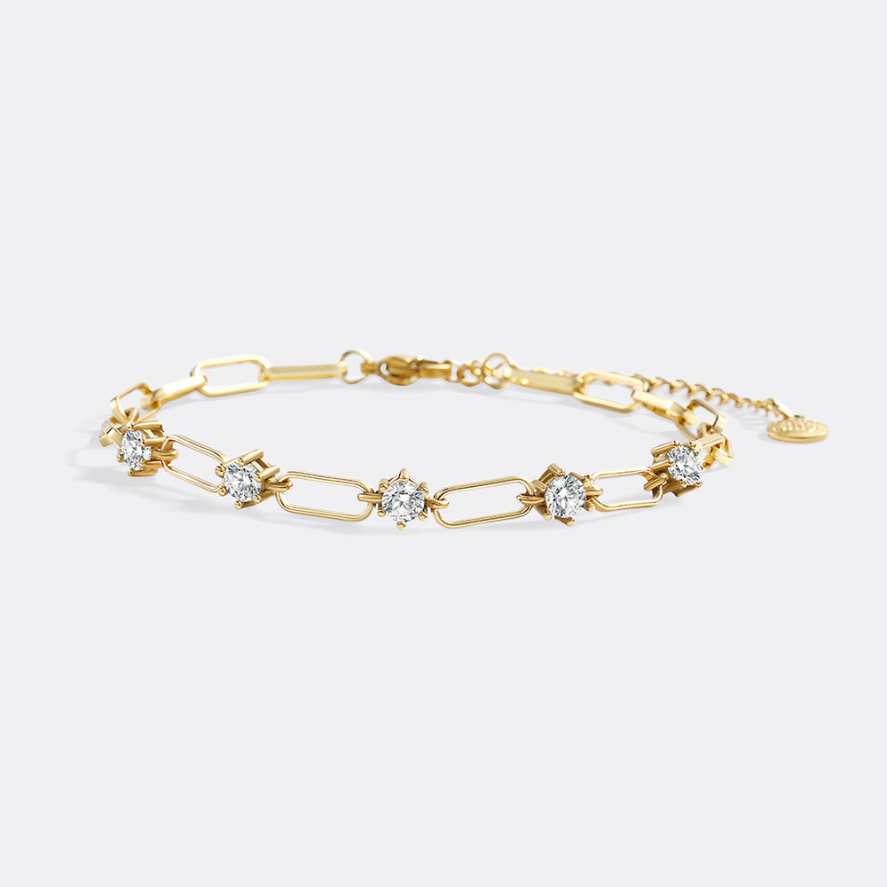 Gold bracelet with diamond accents on a light gray background