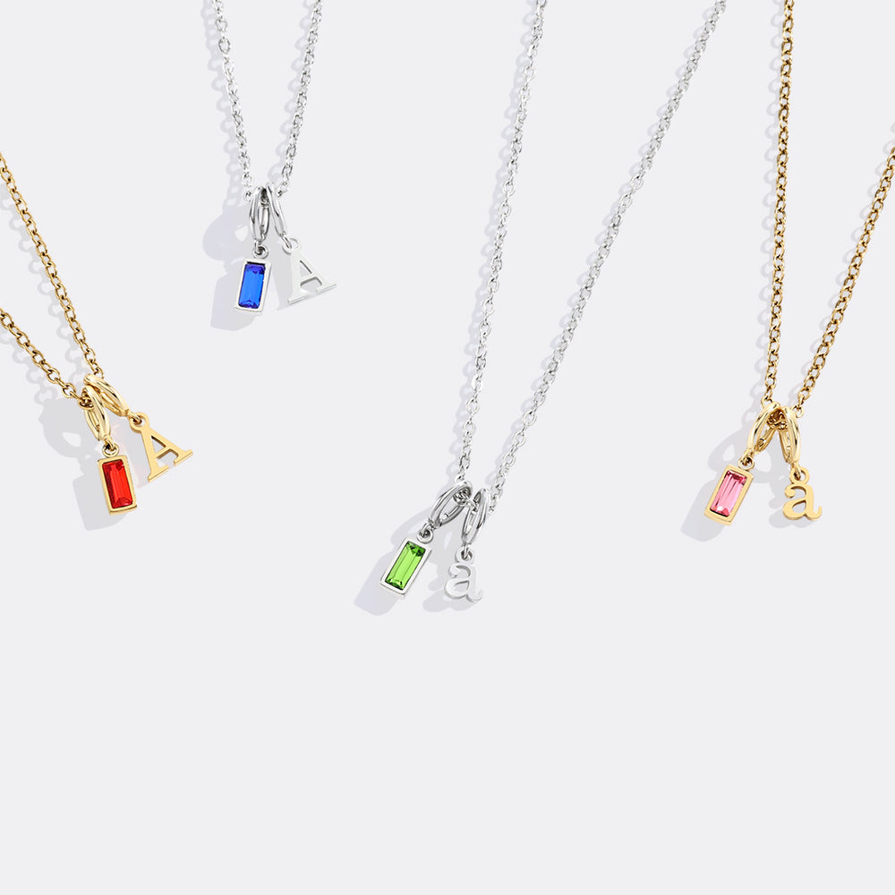 Four necklaces with colorful pendant charms on a white background