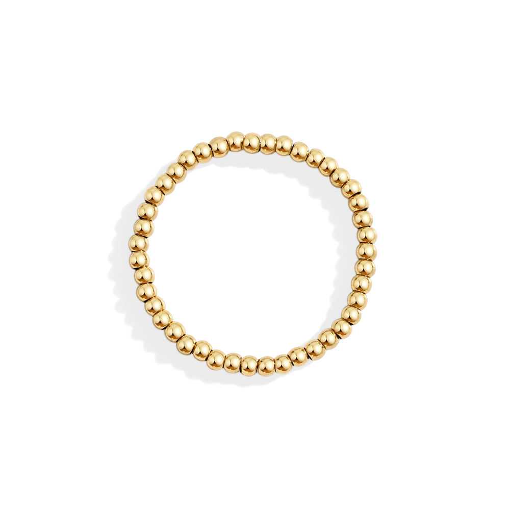 Gold beaded ring on a light gray background
