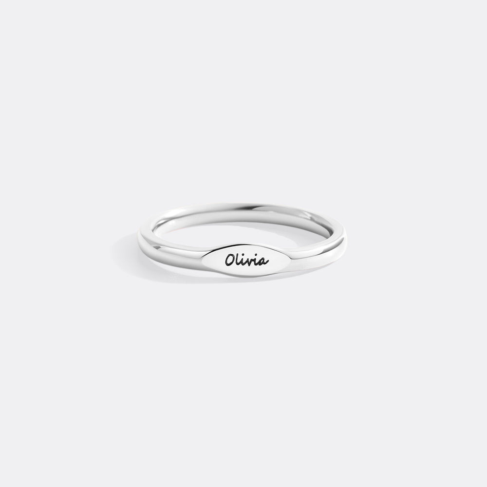 Silver ring with 'Olivia' engraving on a white background