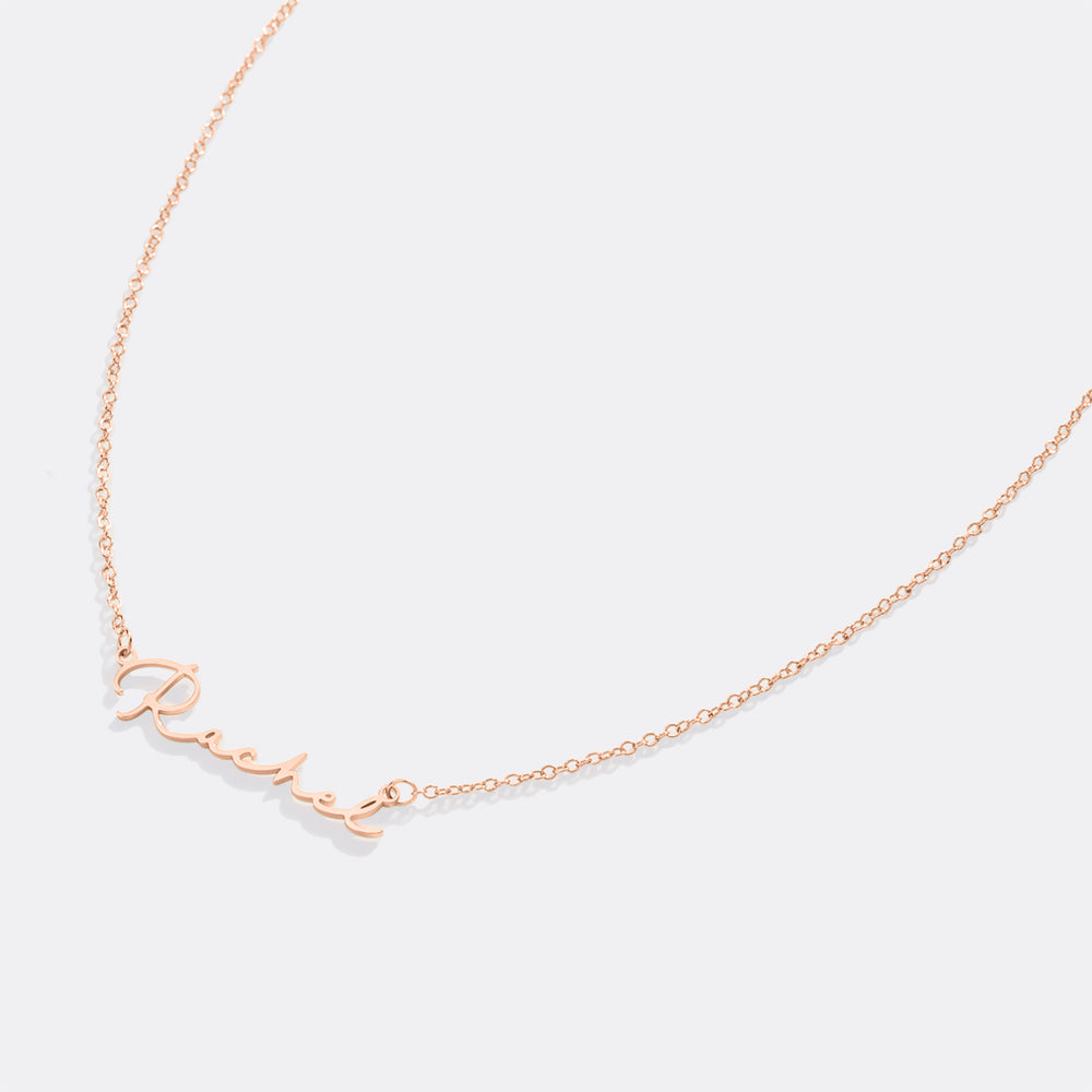 Rose gold necklace with 'Rachael' on a light gray background