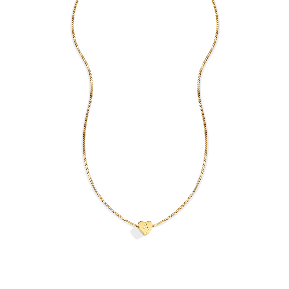 Gold necklace with a heart-shaped pendant on a light gray background