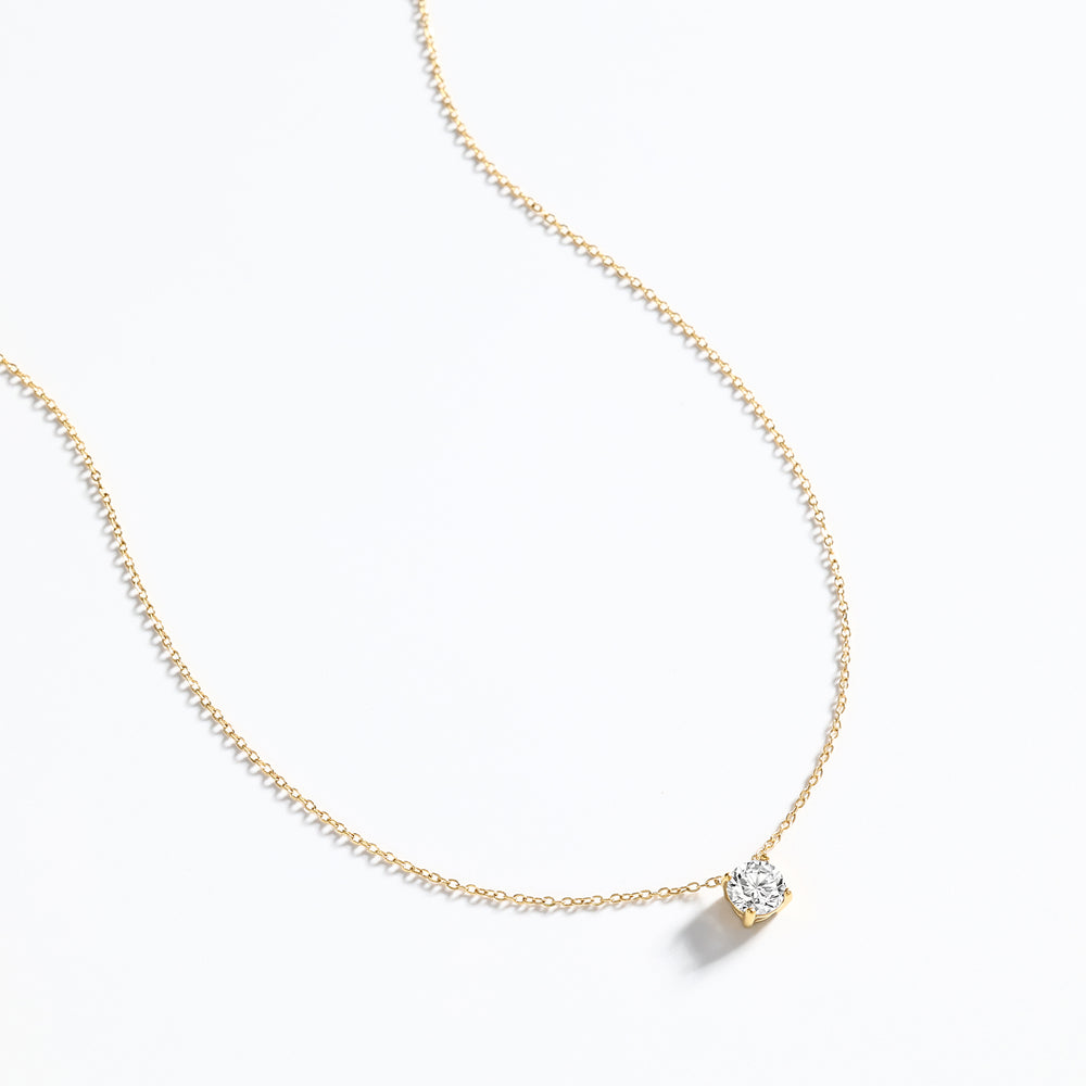 Gold necklace with a diamond pendant on a white background